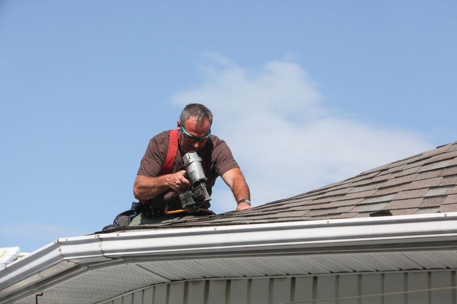 Roofer checking roof closely